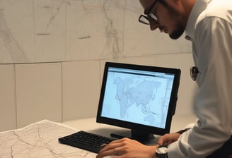 An electric vehicle charging station featuring a red and white design. The station is labeled with 'DC Fast EV Charging Only' and includes a combo connector. It is situated outdoors on a grassy area during nighttime, illuminated by nearby artificial lights.