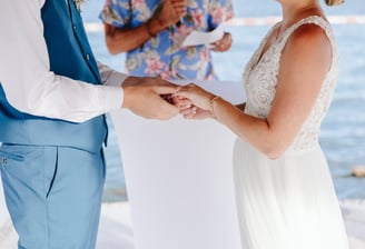 a bride and groom holding hands while they are getting married