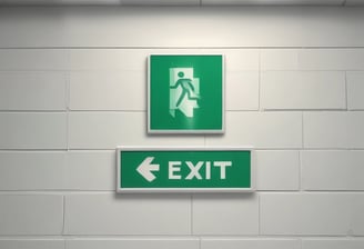 A dark, industrial-style fire safety door is set into a textured concrete wall. The door is equipped with a simple handle and features a sign that states 'Fire Safety Door - Do Not Obstruct - Do Not Keep Open.' Above the door, a small white box is mounted on the wall, possibly an alarm or sensor.