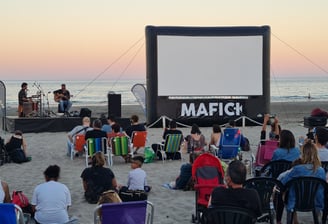 Cine en la playa frente al mar