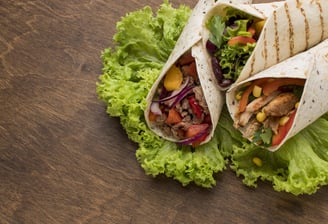 A fully filled taco with seasoned ingredients, including lettuce, tomatoes, and shredded cheese.