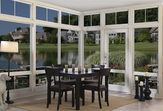 Three 3 seasons sunroom a dining room with a table and chairs