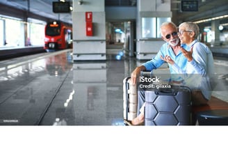 a man and woman sitting on a bench in a train station