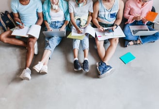 a group of people sitting on a couch with laptops