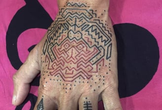 An handpoke tattoo featuring geomatric line symmetrical pattern, art tappis ornaments inspired.