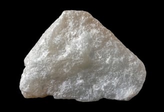 mineral talc, a rock with a piece of white powder on it