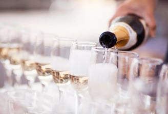 Bartender pouring champagne into flutes in preparing for a wedding toast - Premier Event Staffing