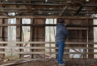 A person prying of wood from a decaying structure