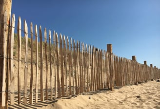 des piquets en bois pour former une ligne sur la plage