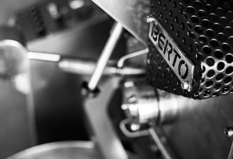 a close up of a coffee roasting machine with a metal frame