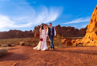 a man and woman standing in front of red rocks at Valley of Fire State Park