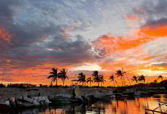a sunset sky with a boat in the water