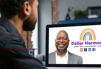 a man sitting at a computer screen looking at his Dollar Harmony Coach and a colored rainbow