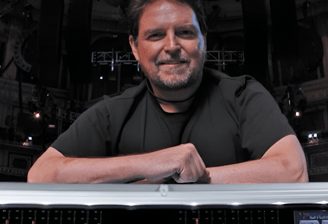 Jon Lemon smiling and leaning on mixing desk.