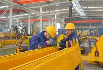Our team expertly assembles large vehicle mounted cranes in our modern factory, showcasing strong manufacturing capabilities.