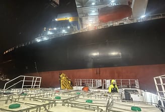 a large ship in the water with a man standing on the deck
