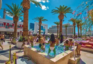 Luxury poolside cabanas and guests enjoying bottle service at a Vegas dayclub, representing VIP tips and upscale planning.