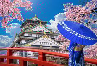 Osaka castle with cherry blossoms with woman in traditional kimono with umbrella