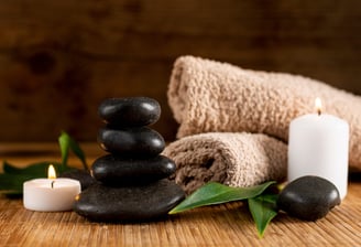 massage stones, candle and towels
