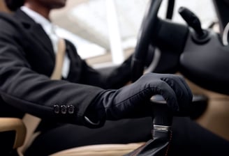 Driver in total black with black golves is driving