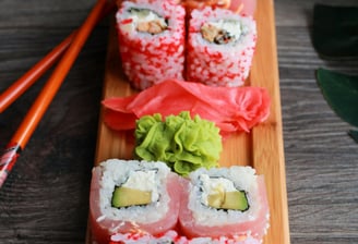 8 red Sushi rolls on a plate with wasabi