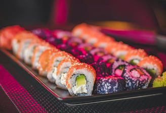 Multiple sushi rolls lined up on a tray