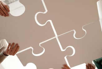 plusieurs personnes qui font un Puzzle montrant l'unité et l'objectif d'entraide de Subvasso