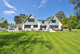 a house with a great lawn surrounding an outdoor patio