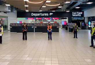 Staff standing apart in the departures security area