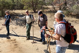 a group of people standing on a dirt road