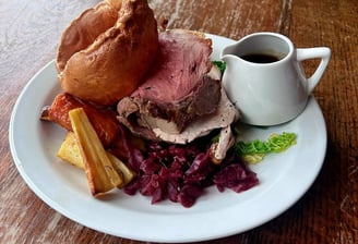 a plate of food with a mug of gravy 