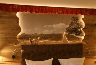 hinterleuchtetes Betthaupt mit Wandtapete in einem Gästezimmer