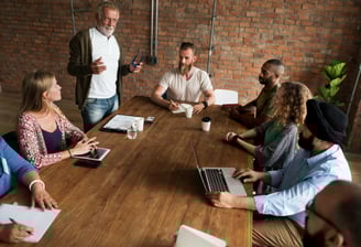 a group of office workers sitting around a table for training