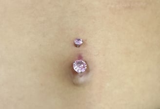 Navel pierced with a double gem barbell