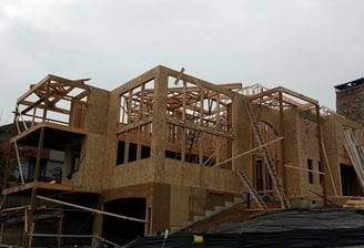 a house being built on a hill with a lot of wood framing