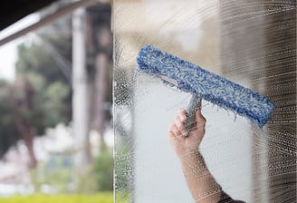 Technician from Like Glass cleaning glass with a squeegee in The Villages