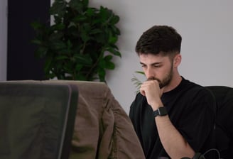a man sitting at a desk with a laptop computer