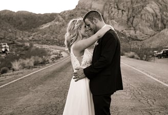 a bride and groom kissing on the road