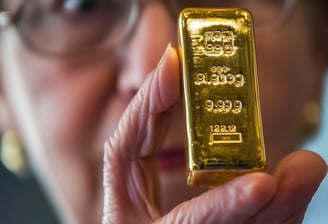 elderly woman holding a gold bar in her hands