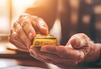 retiree holding gold bar in hands