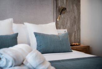 Una cama con una manta y almohadas encima