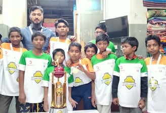 a group of people standing around a table with a trophy