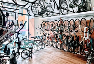 a room with many bikes and bicycles parked in front of a store