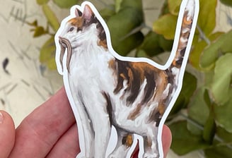 a sticker of a cat with a moustache sitting on a person's hand