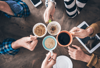 a group of people holding coffee cups and drinking coffee