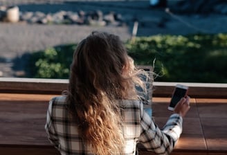 a woman sitting on a bench looking at her cell phone