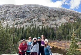Group of women hikers posing in front of a rocky mountain and pine forest near Alma, Colorado.