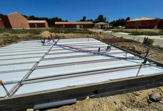 Dalle de plancher hourdis en cours de construction avec des maisons en chantier en arrière-plan.