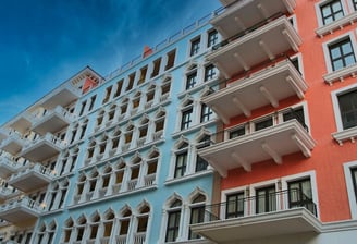 Colorful modern apartment building with blue and orange exterior walls and decorative arches.
