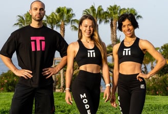 three people standing in front of a body of water